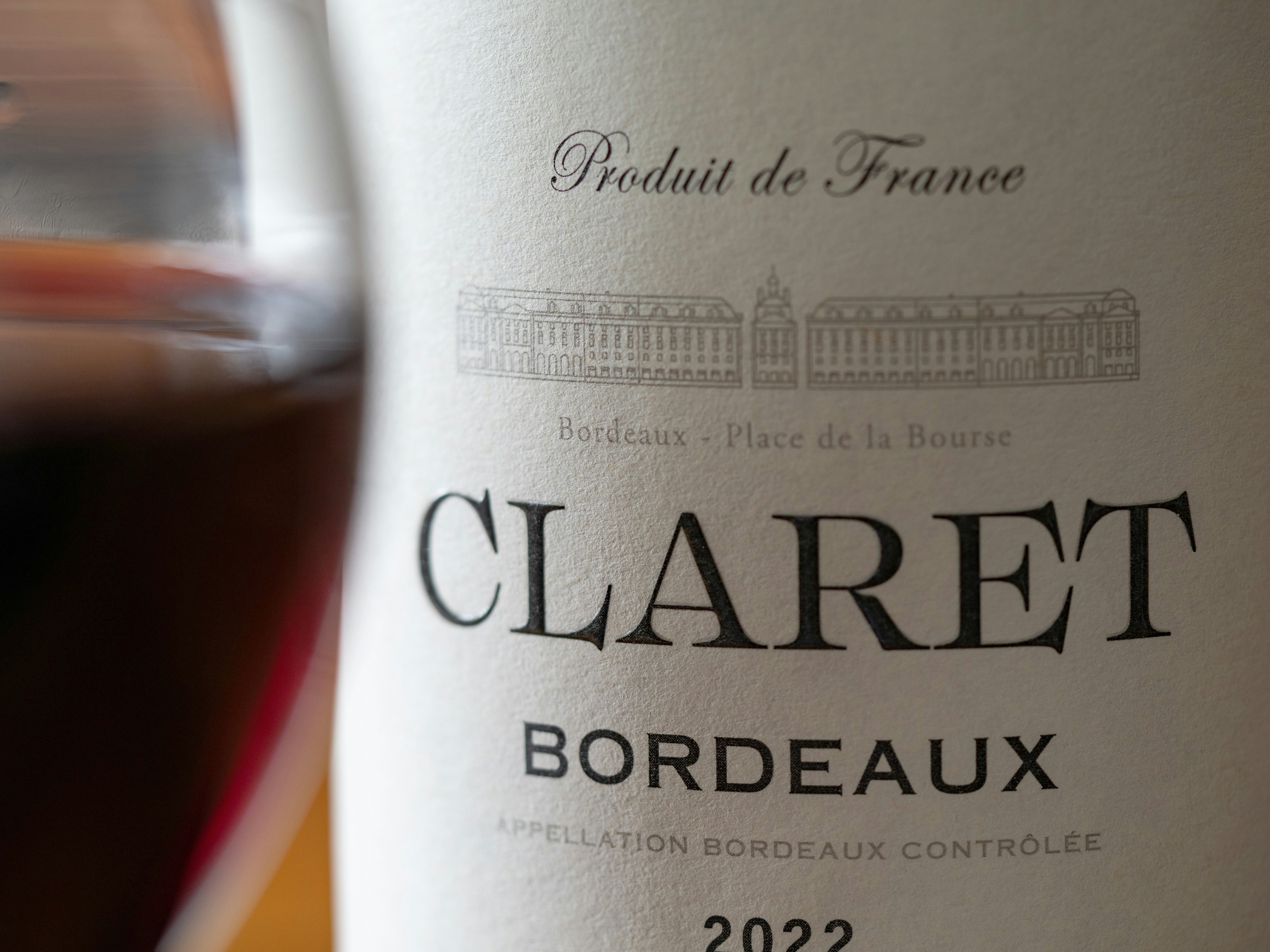 Deep ruby Bordeaux wine in crystal glass, dark cellar background