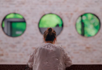 A woman standing in front of a wall with round windows
