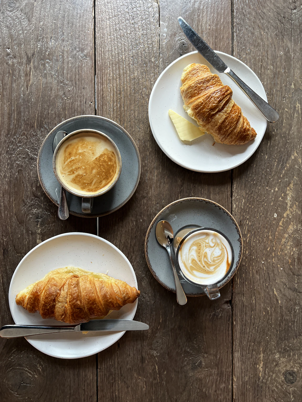 Croissants y café servidos en una mesa de madera