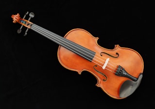 A violin is laying on a black surface