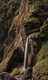 A person standing in front of a waterfall