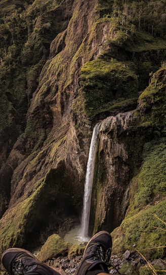 A person standing in front of a waterfall