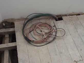 A pile of wires sitting on top of a wooden floor