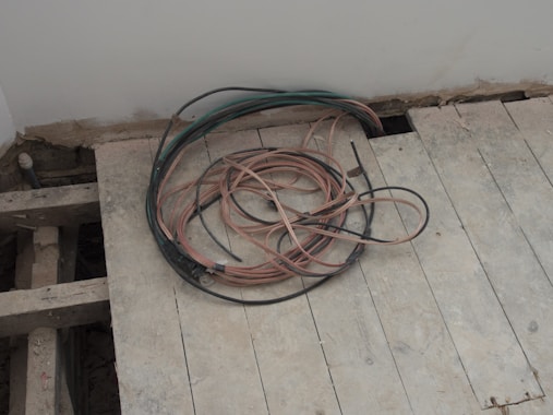 A pile of wires sitting on top of a wooden floor