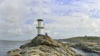 A lighthouse on top of a rocky outcropping