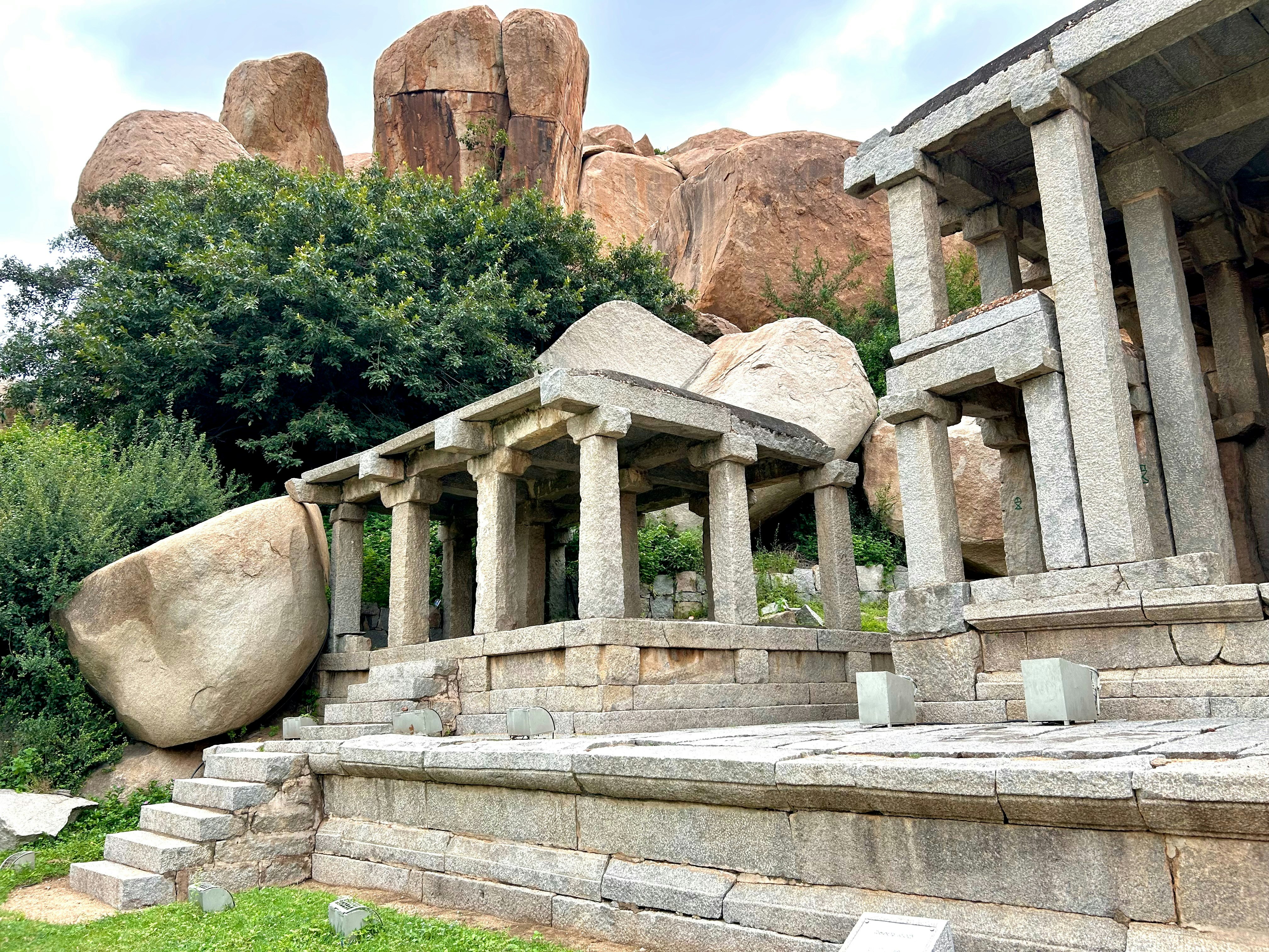 A large rock sitting next to a stone building
