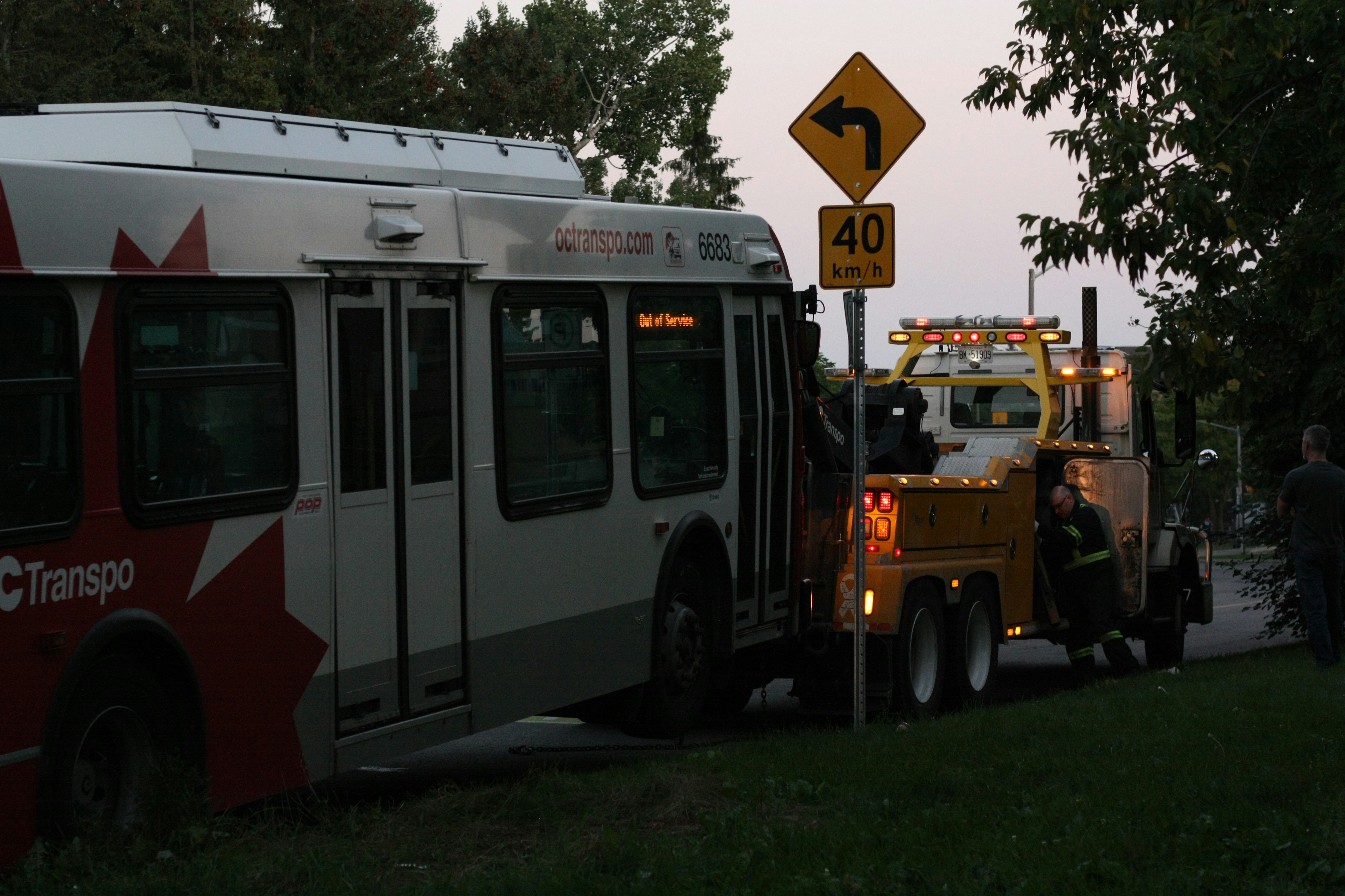 A tow truck towing a bus down a street