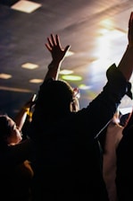 A crowd of people raising their hands in the air