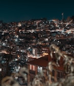 A view of a city at night from the top of a hill