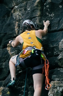 A woman climbing up the side of a mountain