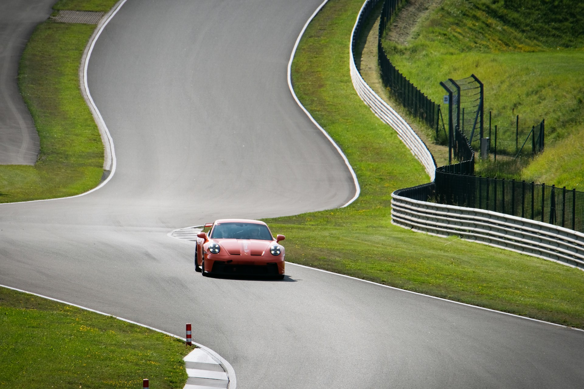 A red car driving down a winding road