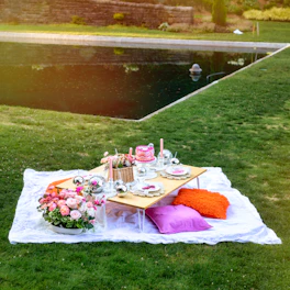 A picnic table set up on a blanket in the grass