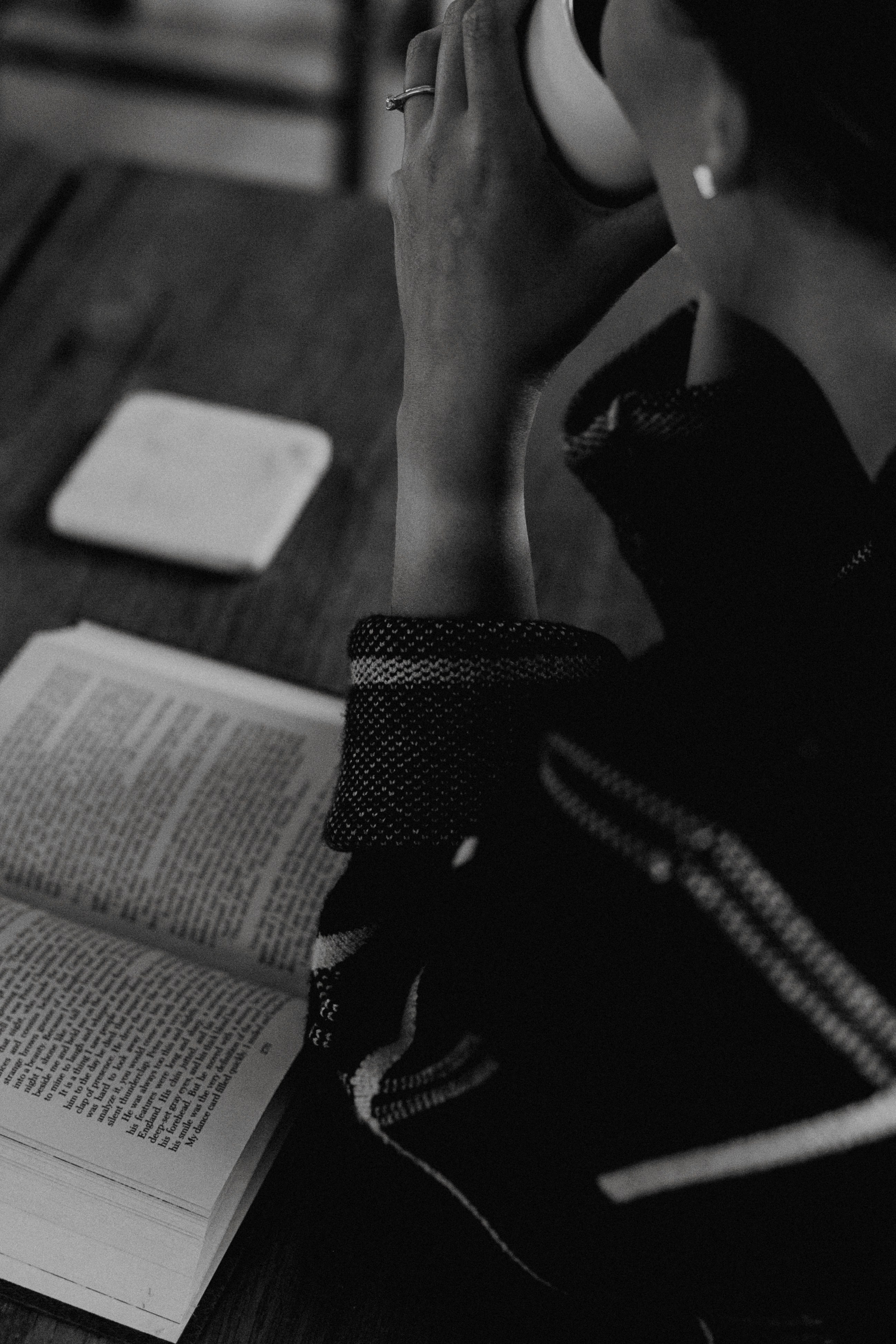 A woman sitting at a table with a book and headphones
