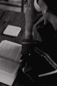 A woman sitting at a table with a book and headphones