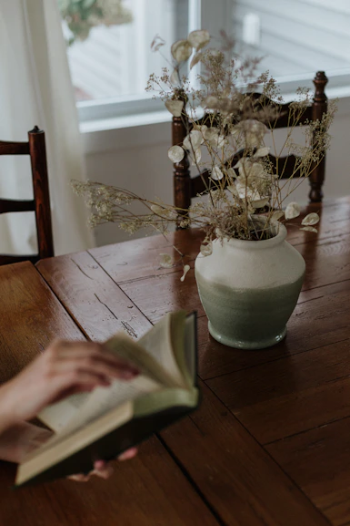 A person sitting at a table reading a book