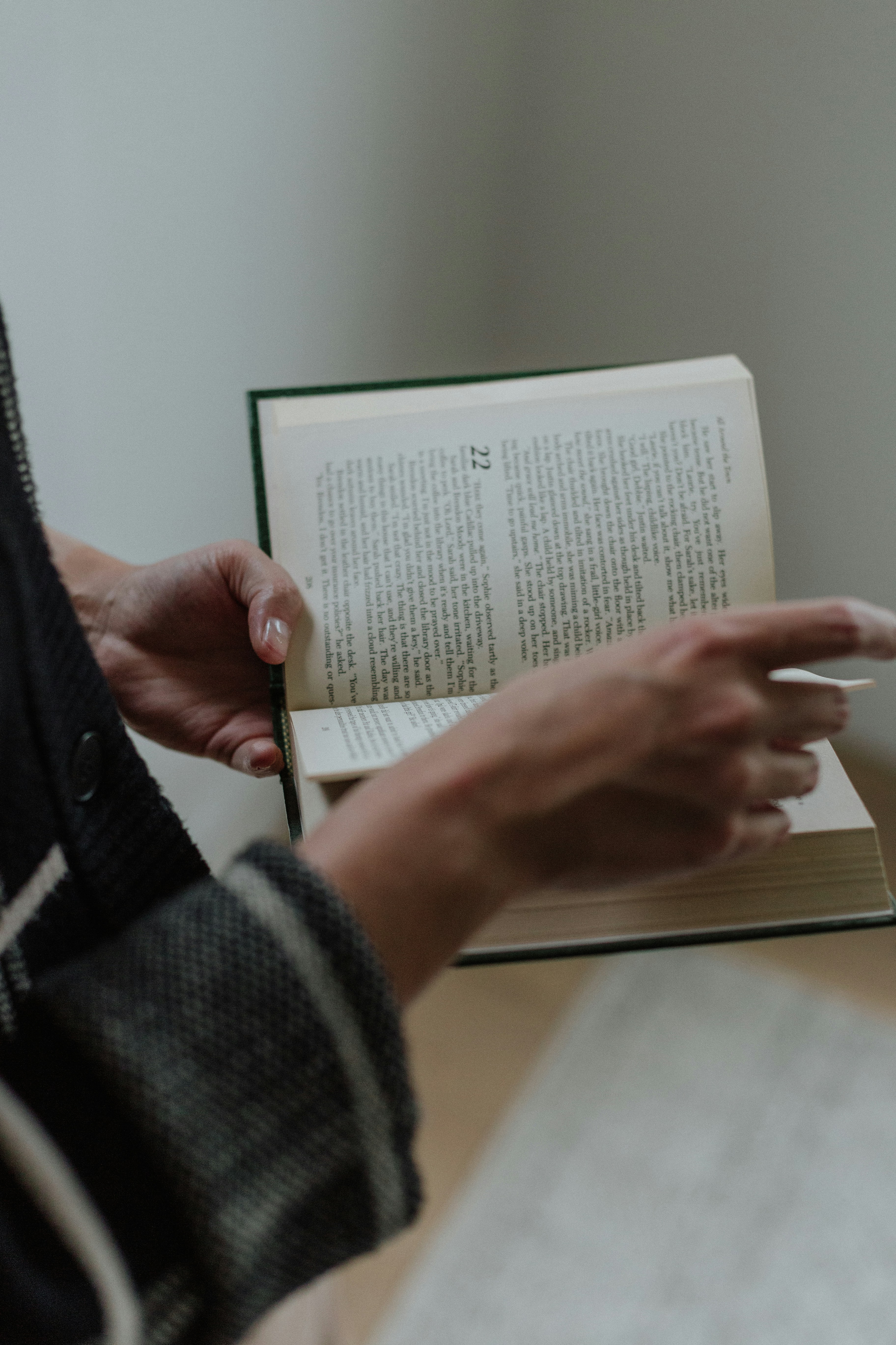 A person is reading a book on a table