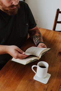 A man sitting at a table reading a book