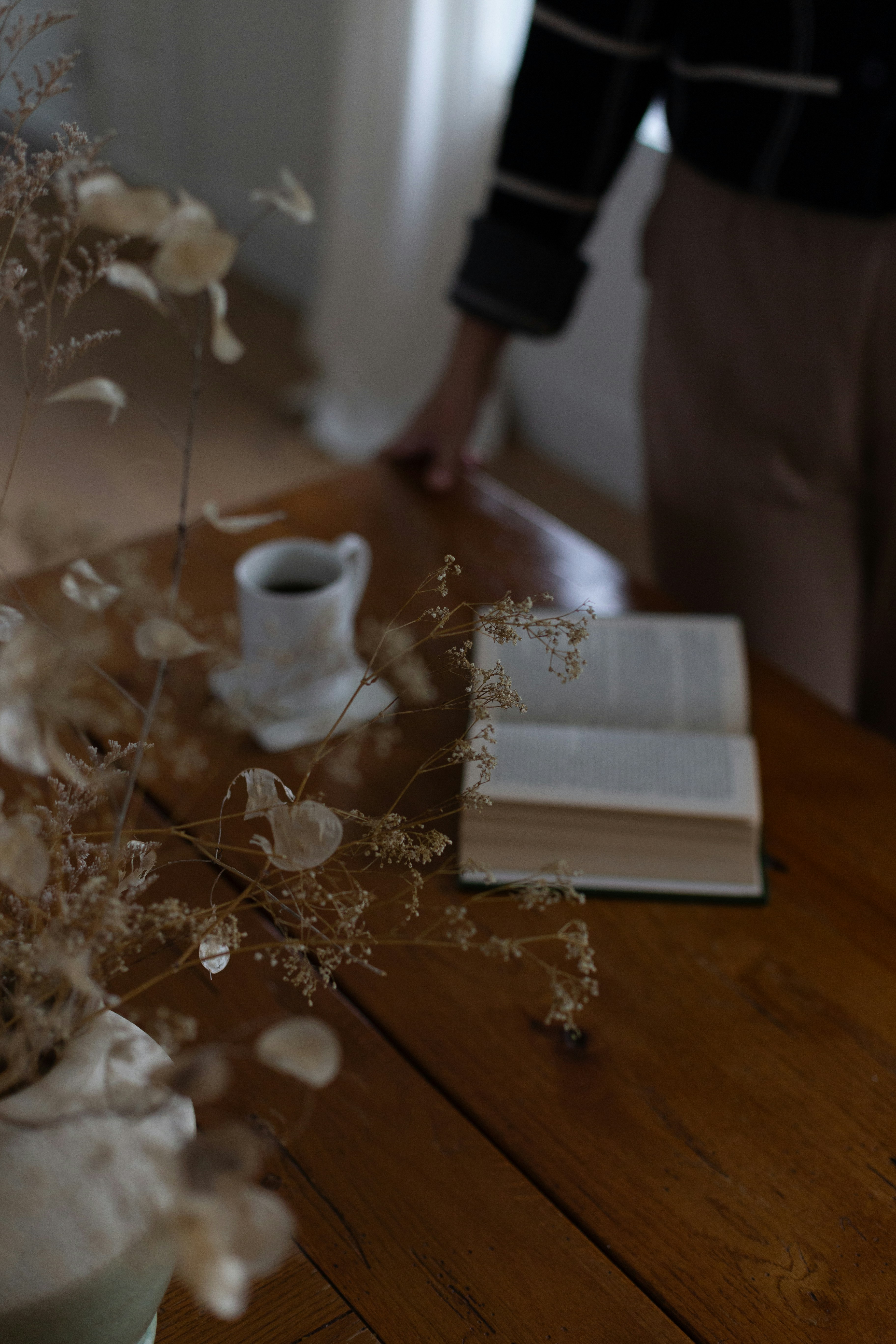 A person standing next to a table with a book on it