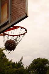 A basketball going through the net of a basketball hoop