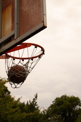 A basketball going through the net of a basketball hoop