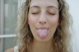 A woman sticking her tongue out with her eyes closed