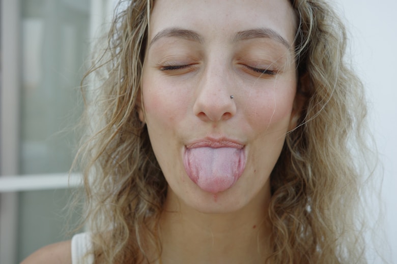 A woman sticking her tongue out with her eyes closed
