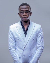 A man in a white suit posing for a picture