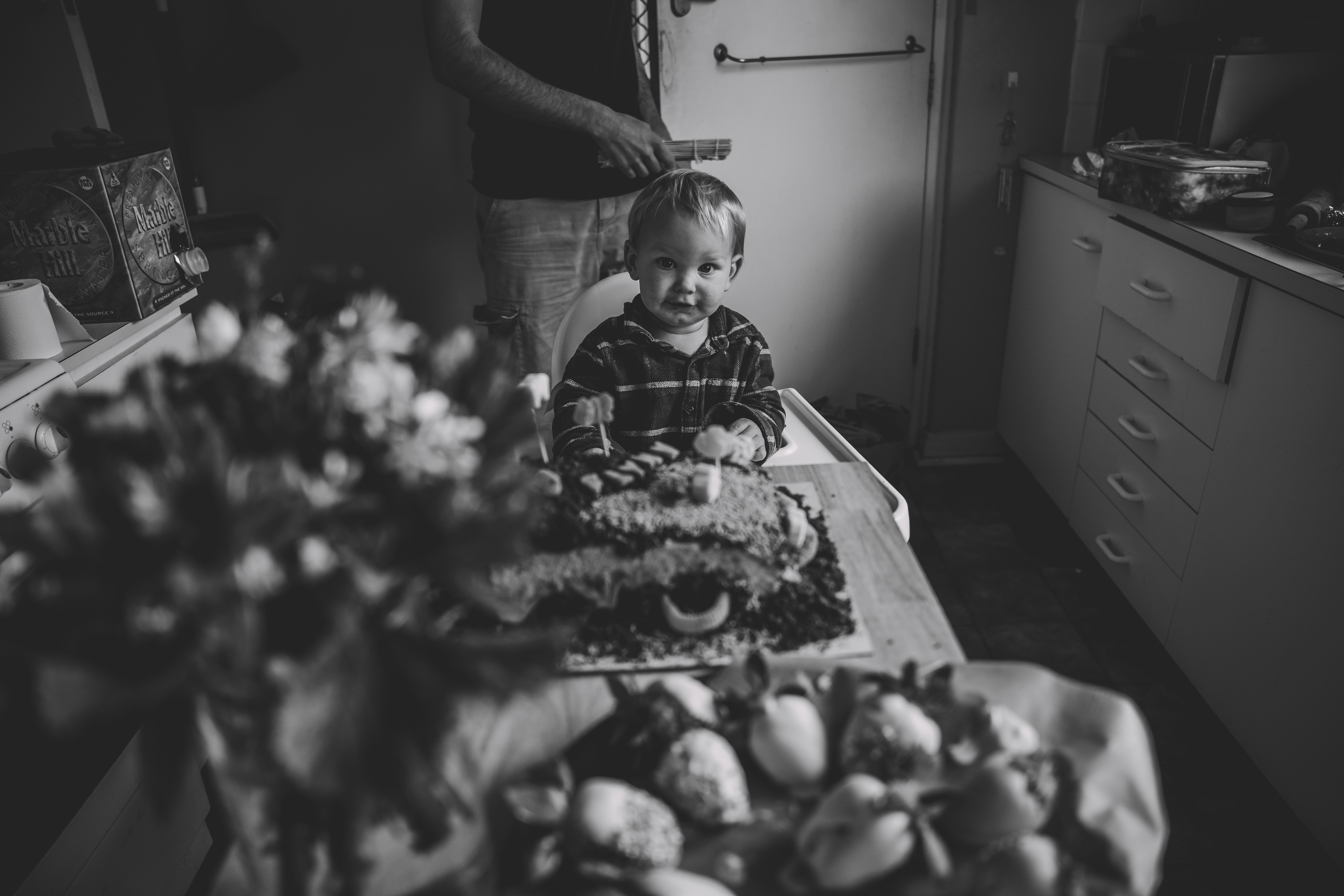 A little boy sitting in front of a table full of food
