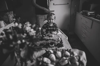 A little boy sitting in front of a table full of food