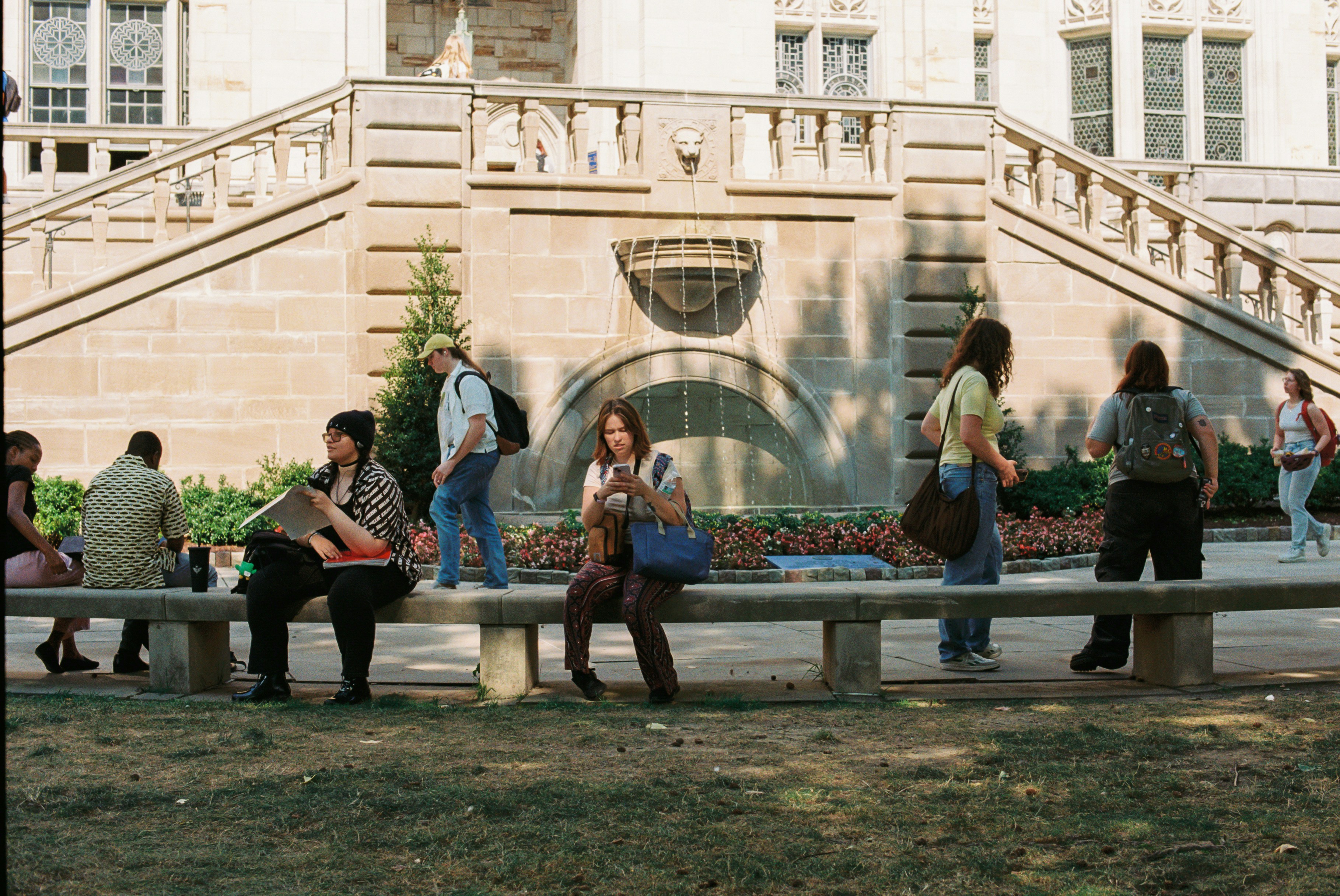 A group of people sitting on top of a wooden bench
