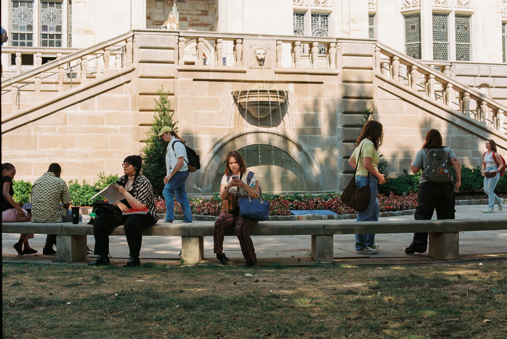 A group of people sitting on top of a wooden bench
