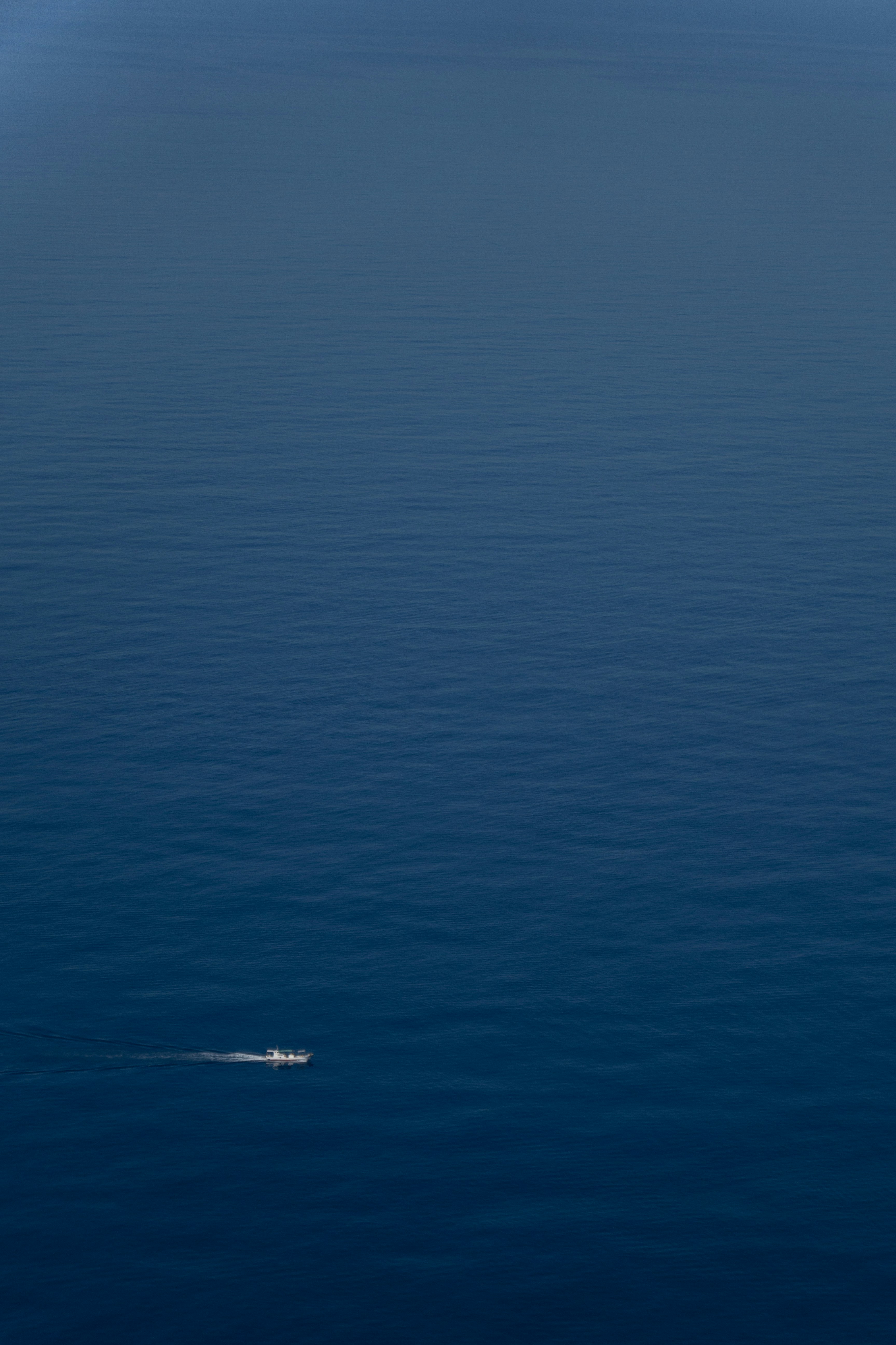 A small boat in the middle of a large body of water