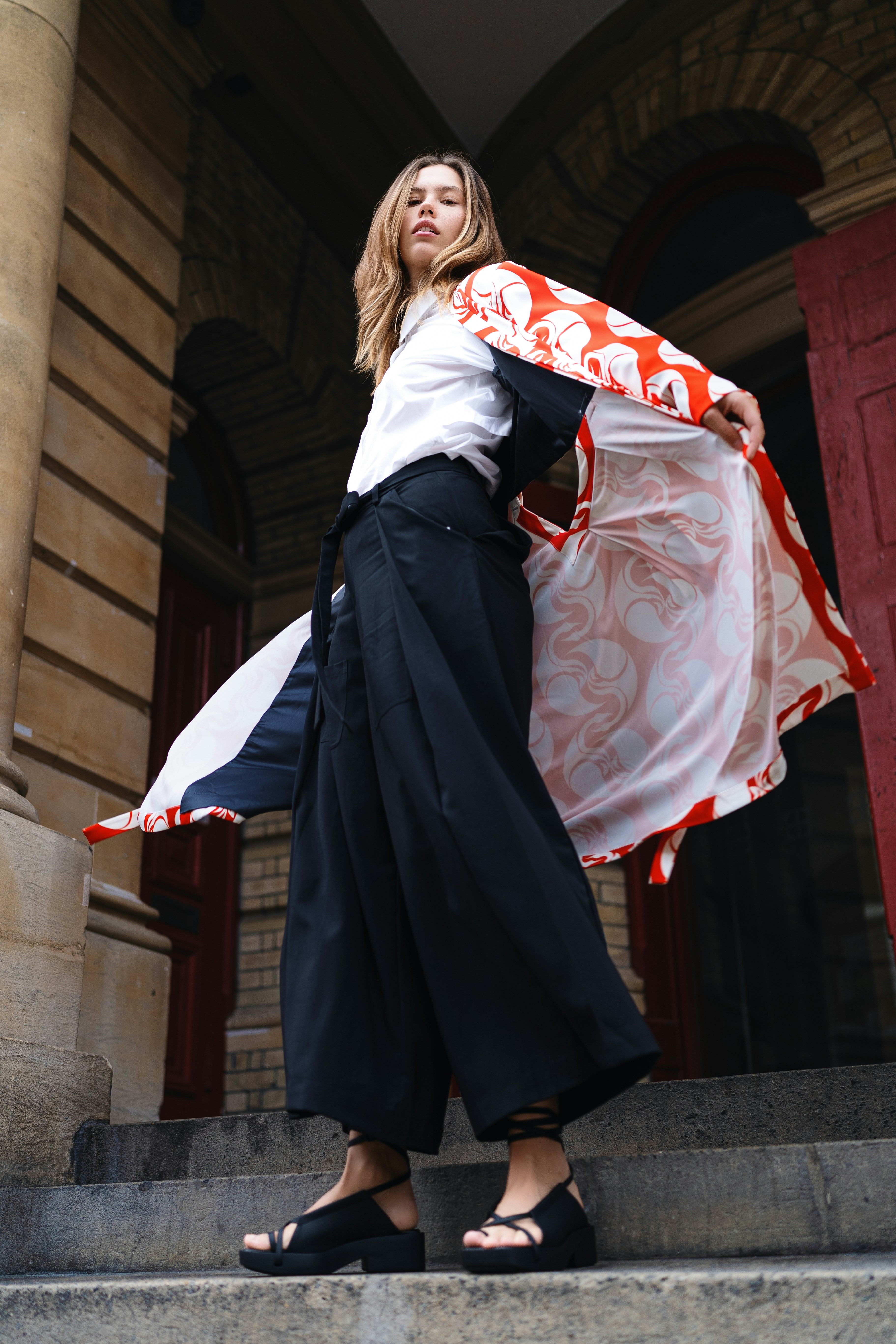 A woman is standing on the steps of a building