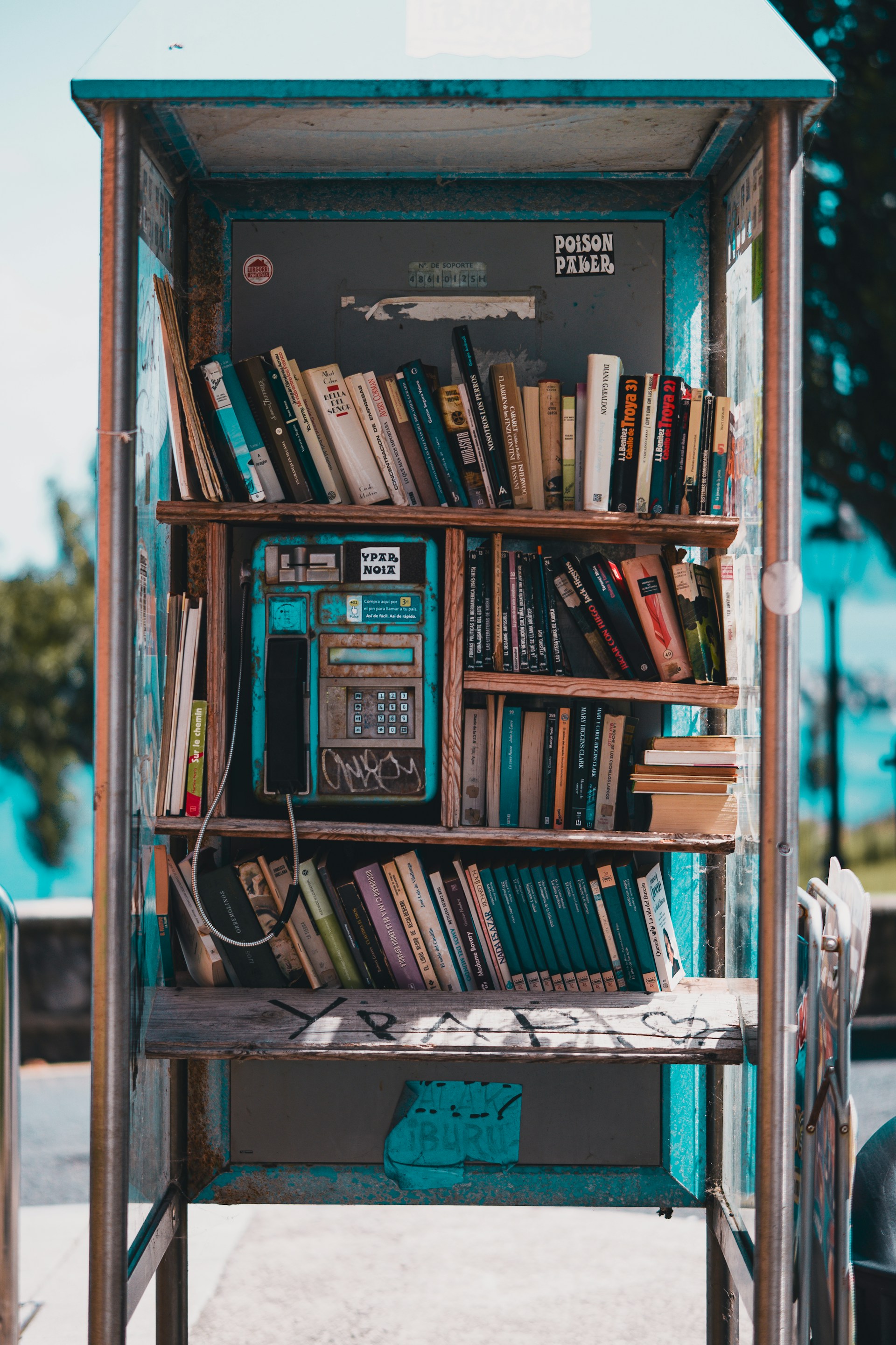 A phone booth with a book shelf full of books