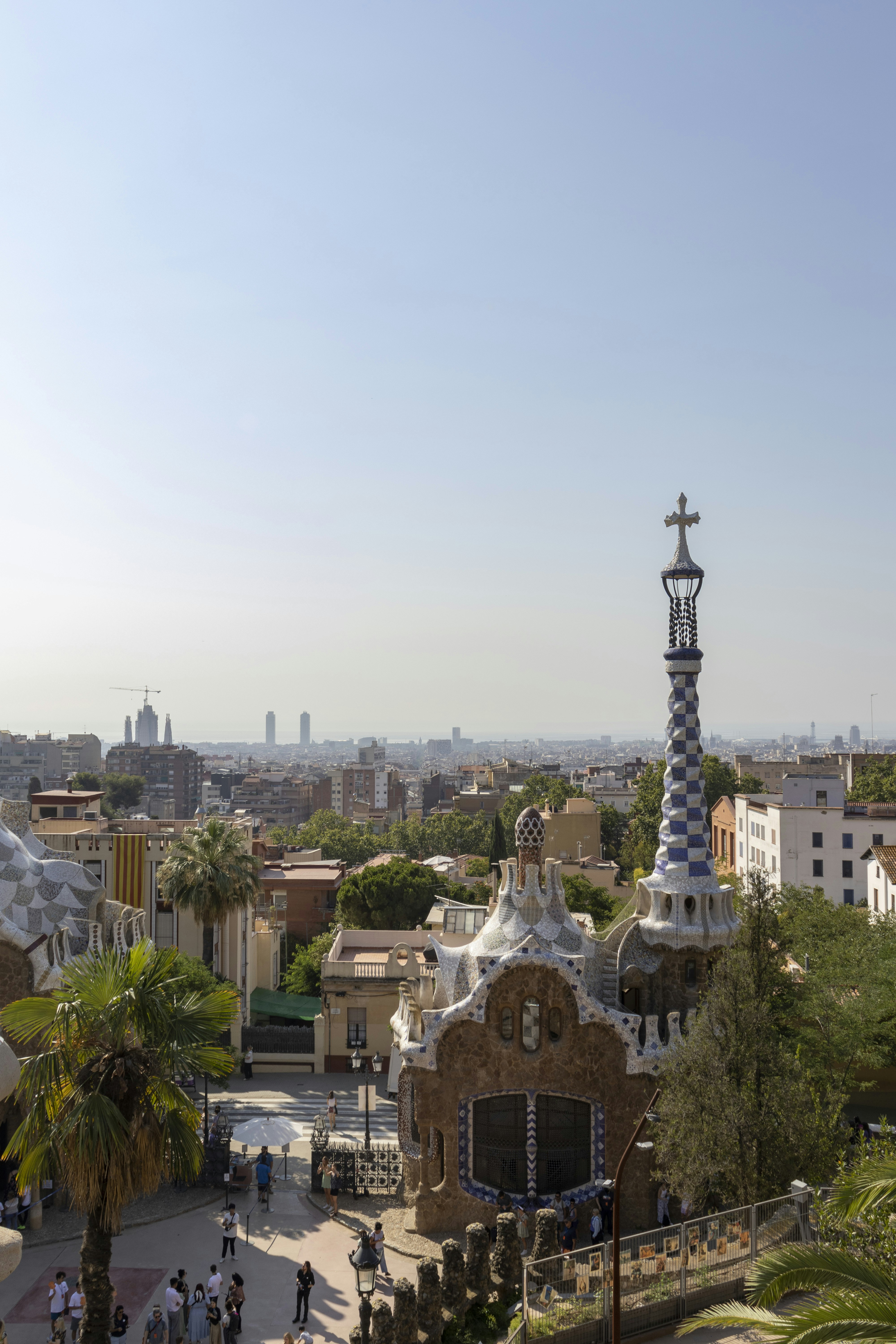 Colorful mosaic architecture of Parc Guell in Barcelona with city skyline in background