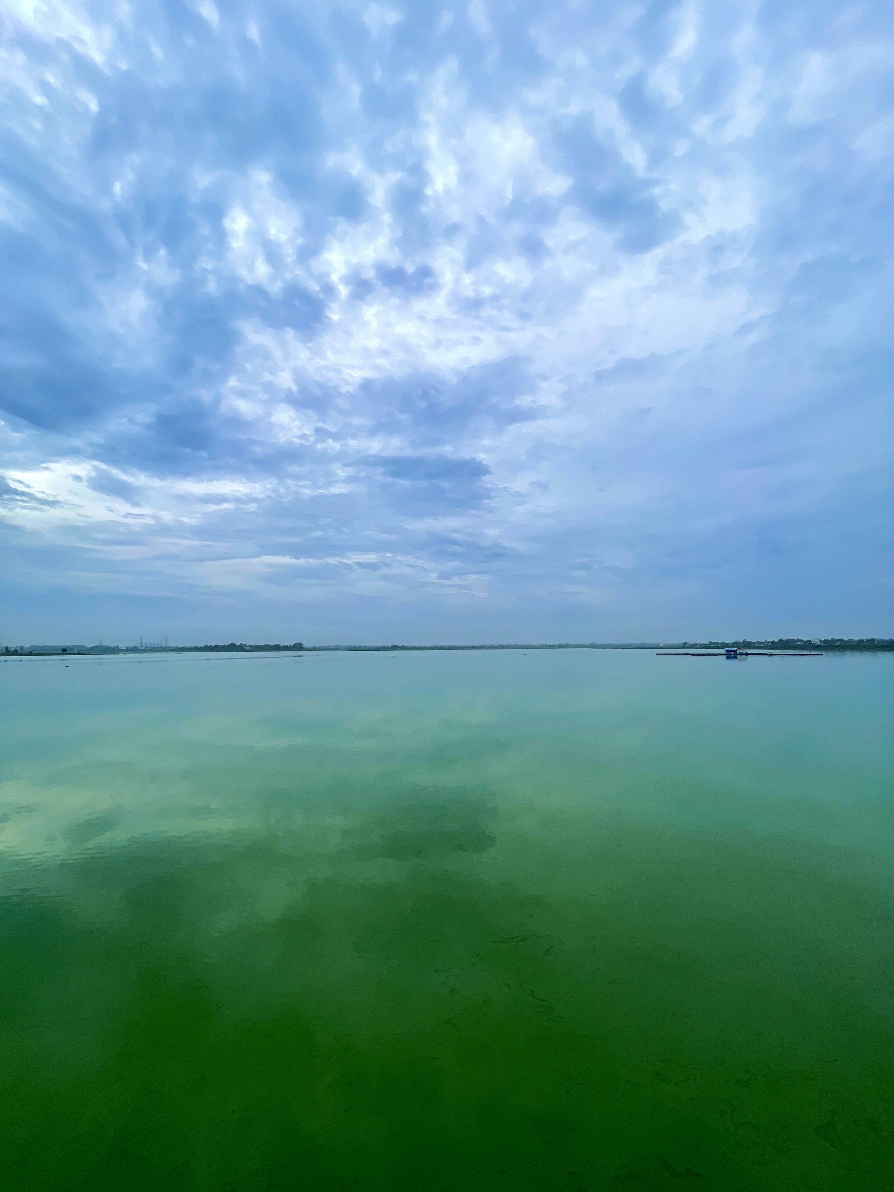 Ein großes Gewässer mit einem Himmel im Hintergrund