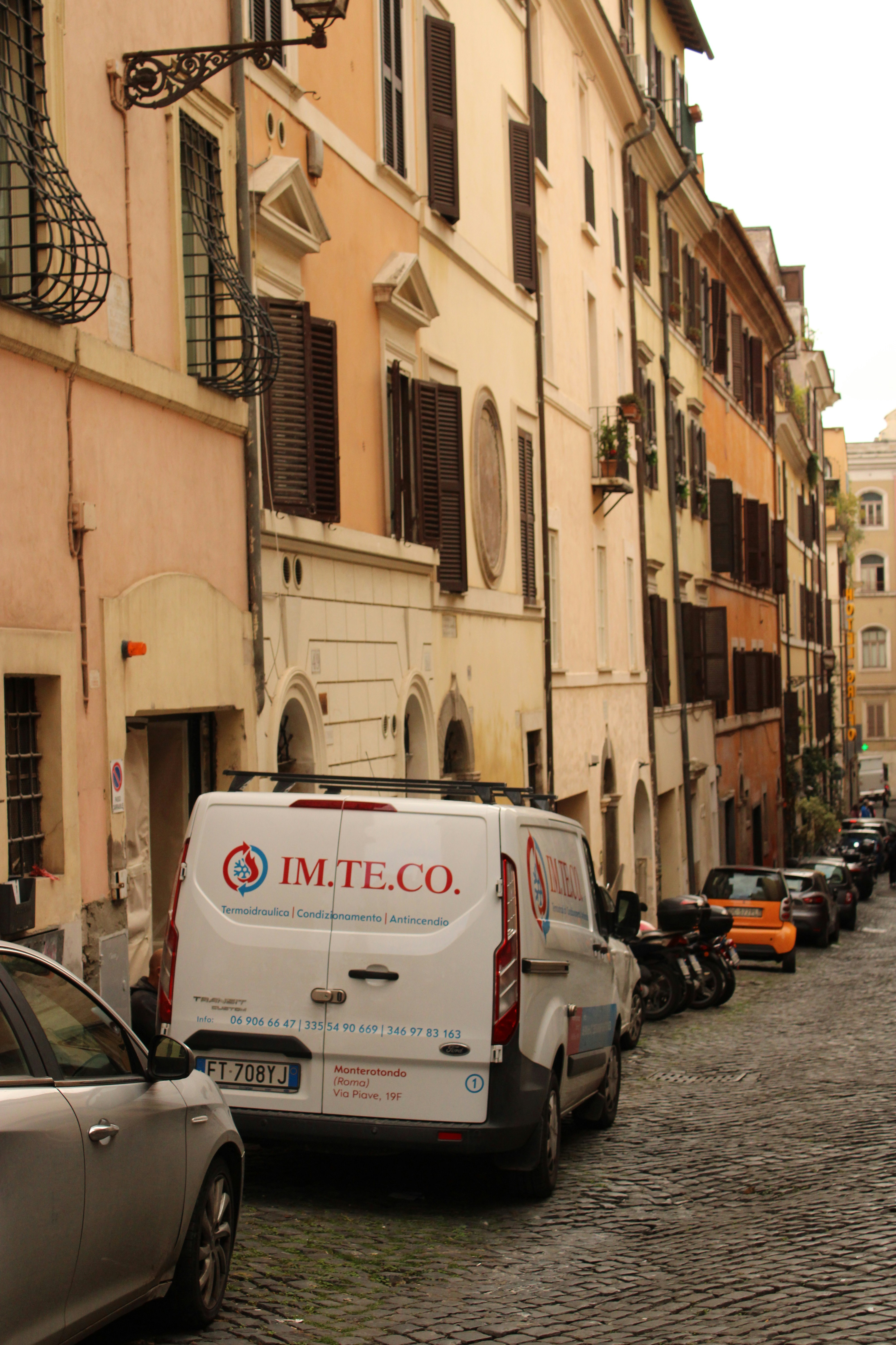 A row of parked cars on a cobblestone street photo – Free Car Image on ...