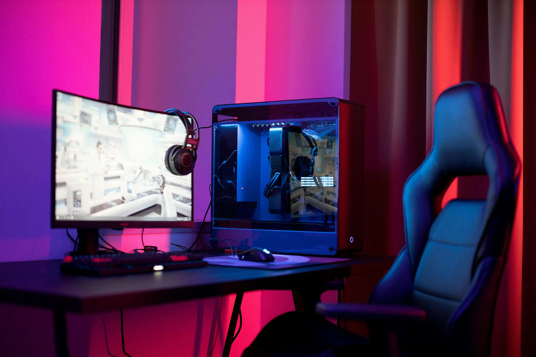 Dark gaming station with gaming monitor, gaming headset, keyboard and gaming chair