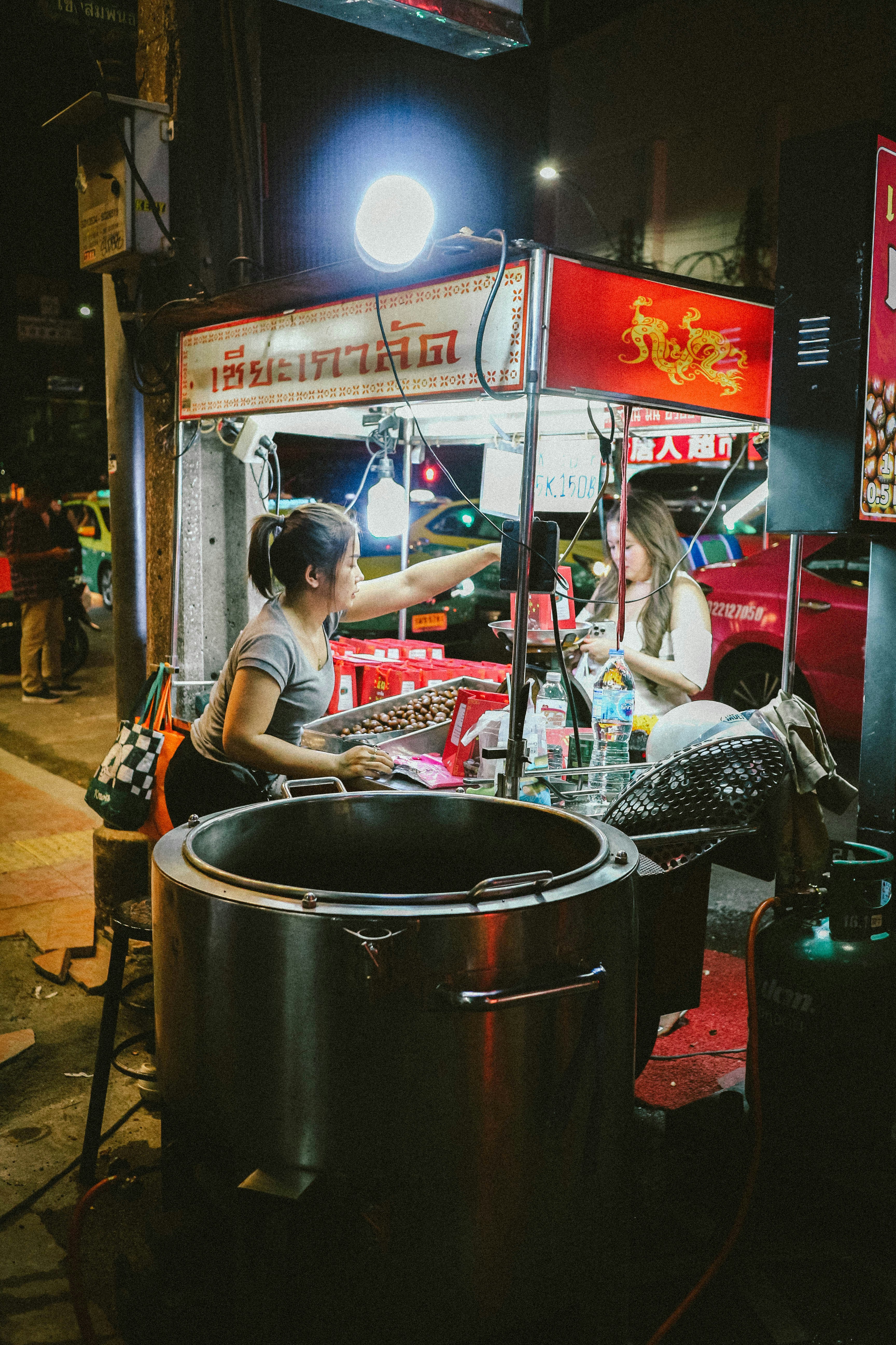 A group of people sitting around a food stand