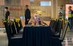 A group of people standing around a table with flowers on it