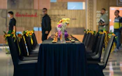 A group of people standing around a table with flowers on it