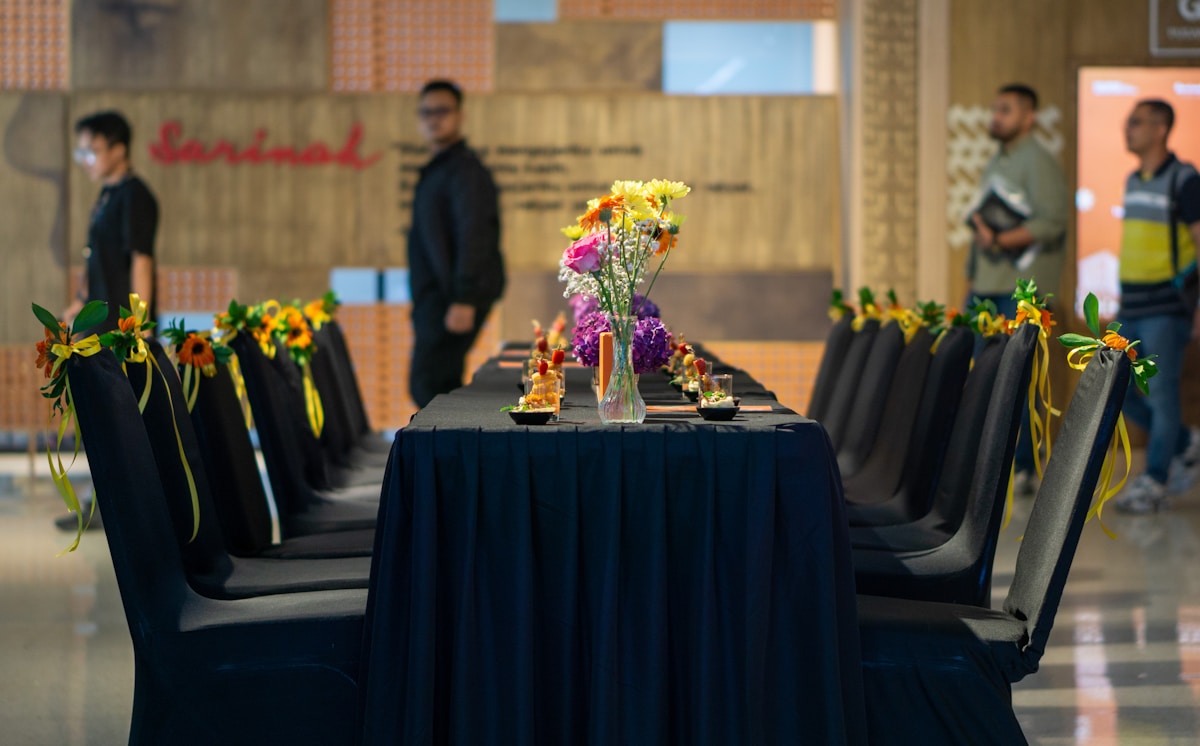 A group of volunteers smiling around a table with flowers, embodying appreciation and recognition.
