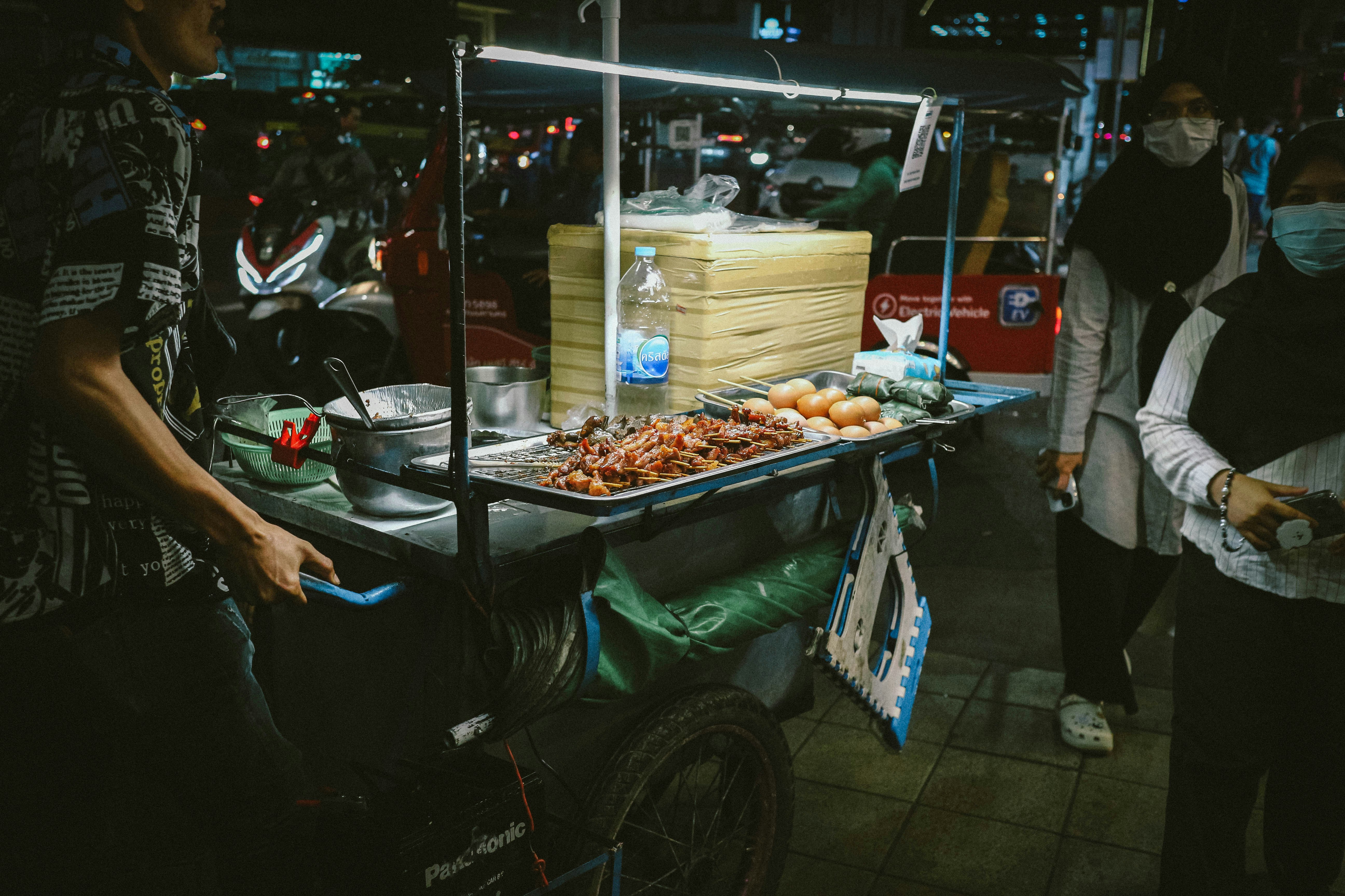 A woman standing next to a table filled with food