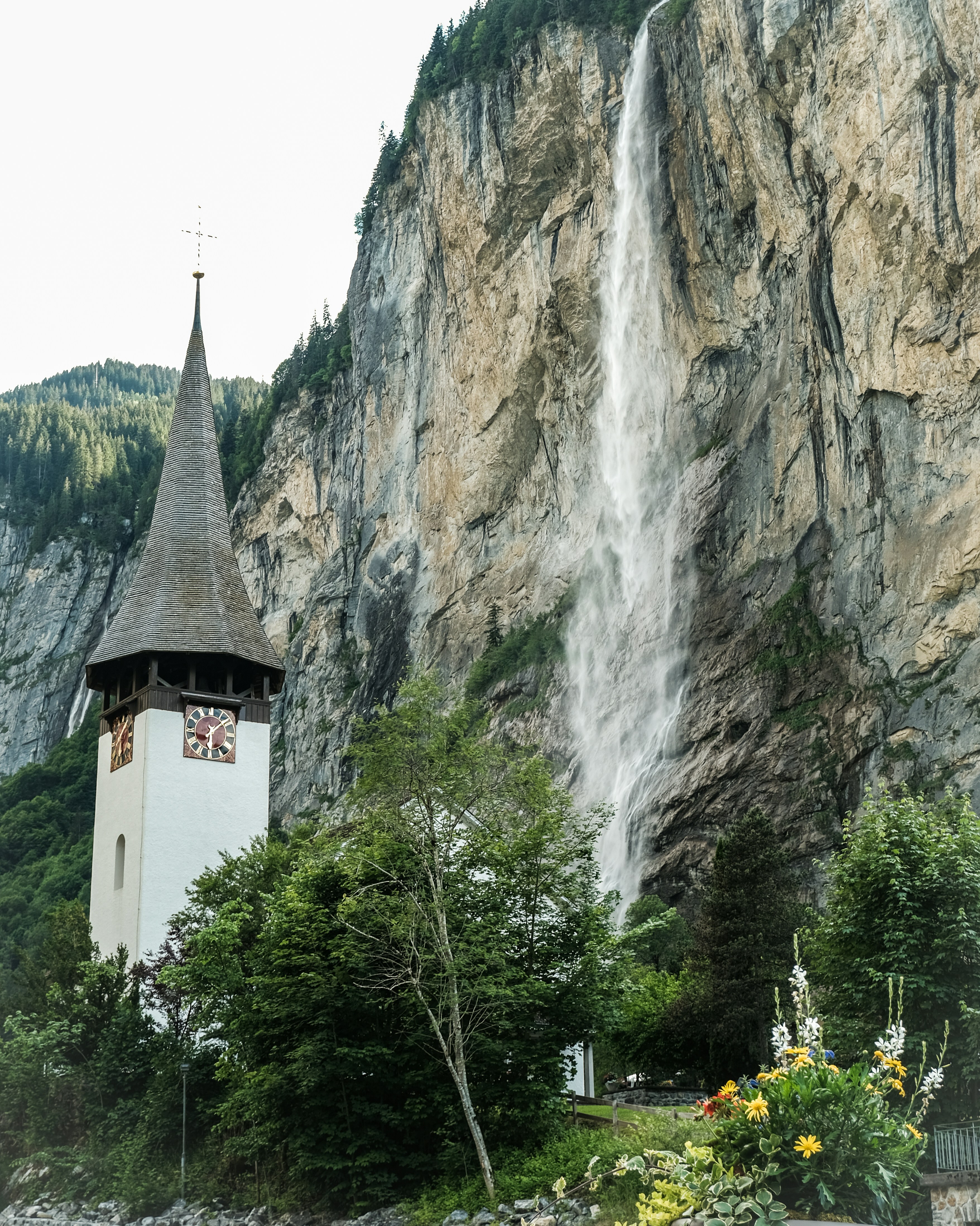Una chiesa con una cascata sullo sfondo