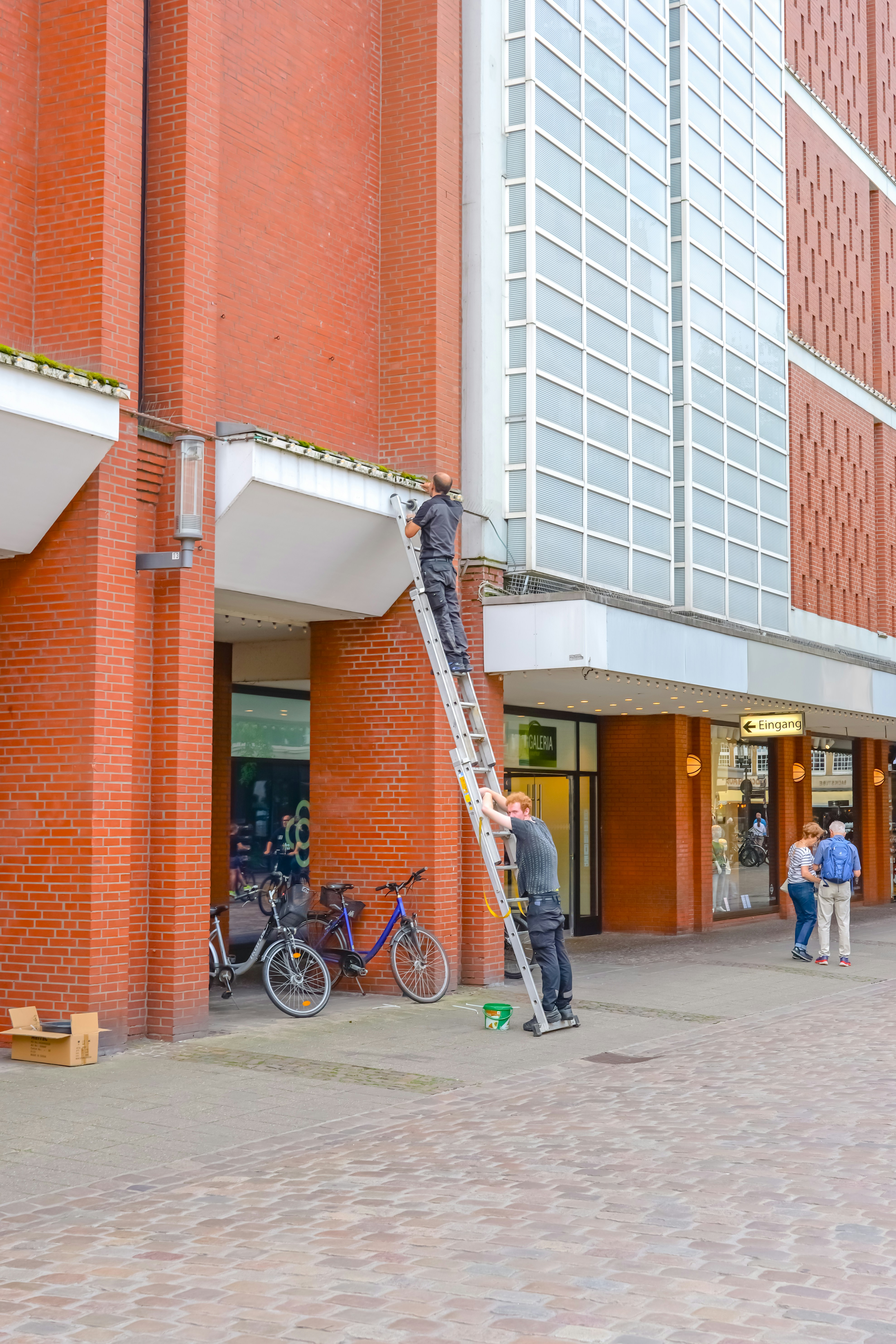 Arbeiter führen Wartungsarbeiten an einer Leiter auf einer Stadtstraße durch.