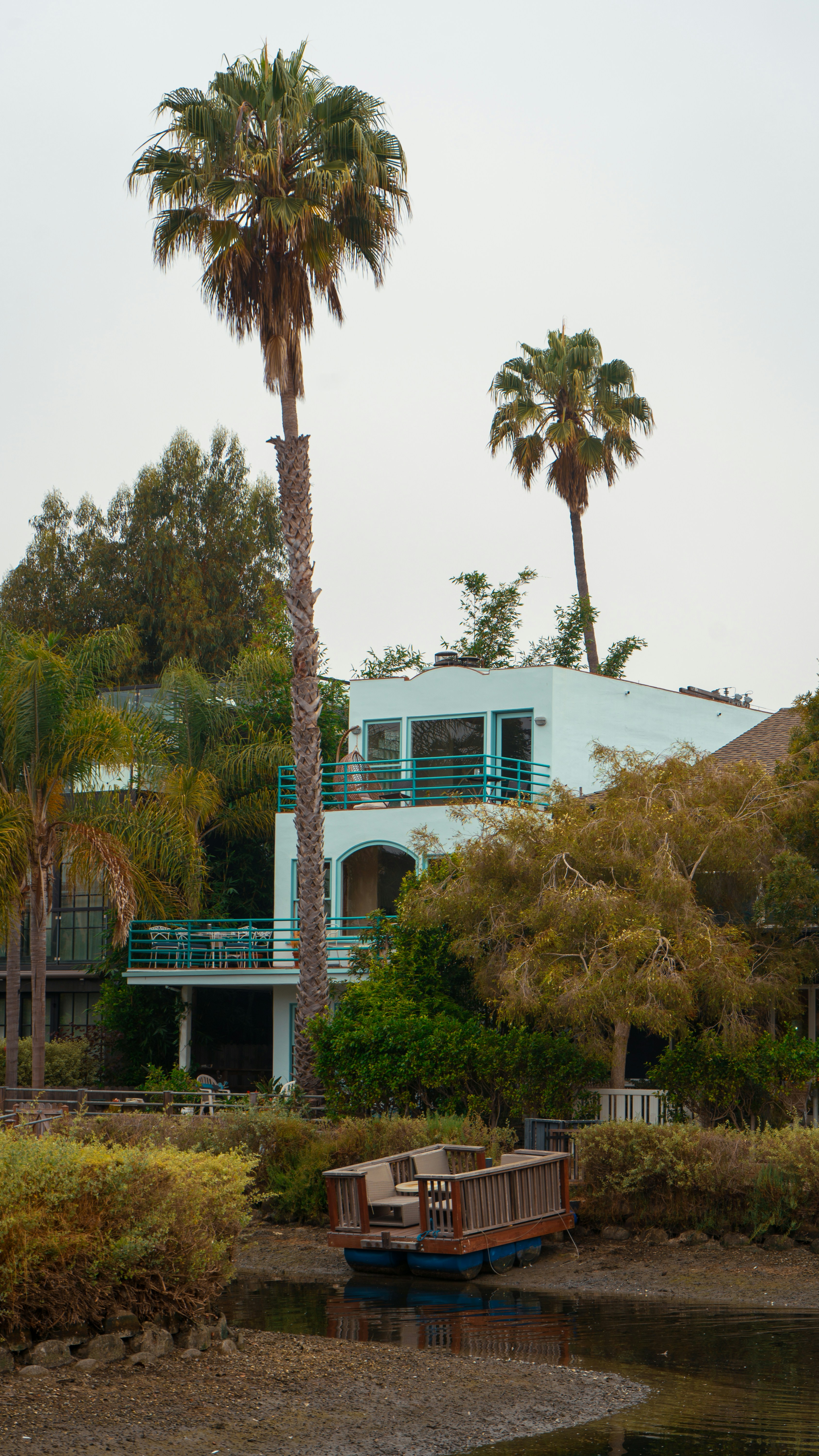 A house with palm trees and a boat in the water photo – Free Instagram ...