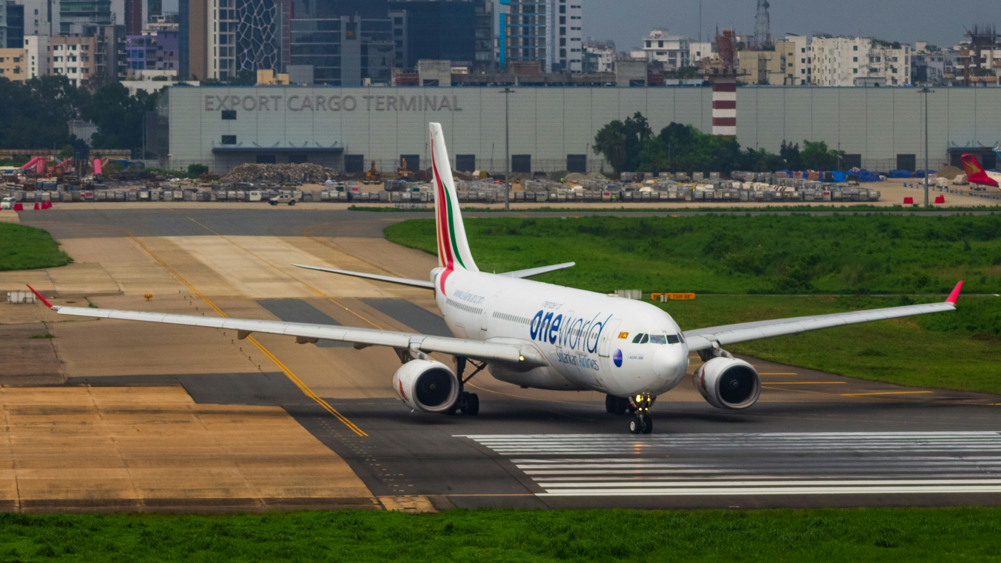 A large white airplane on a run way, Srilankan OneWorld A330