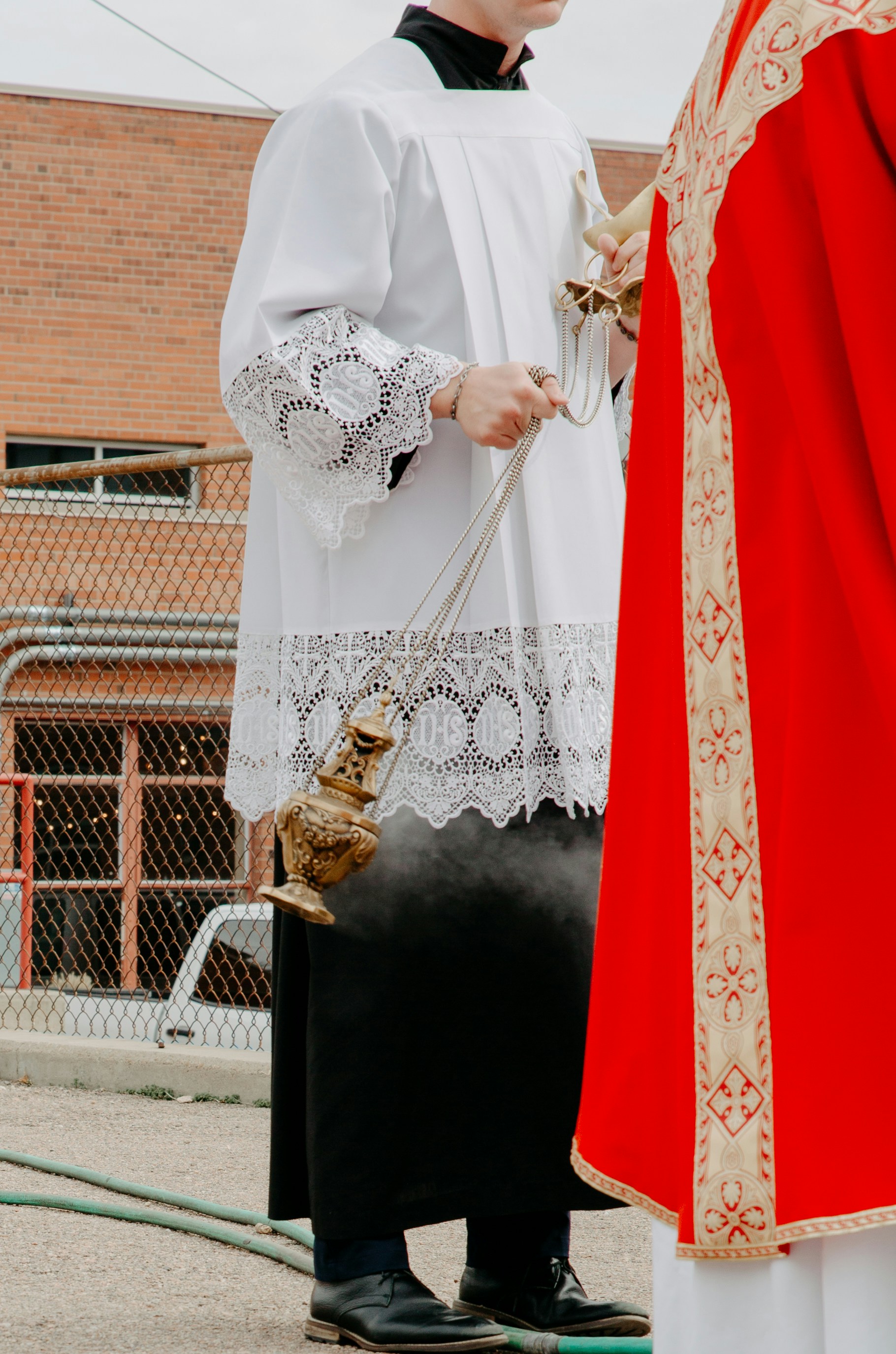 A man in a priest's outfit standing next to a man in a priest