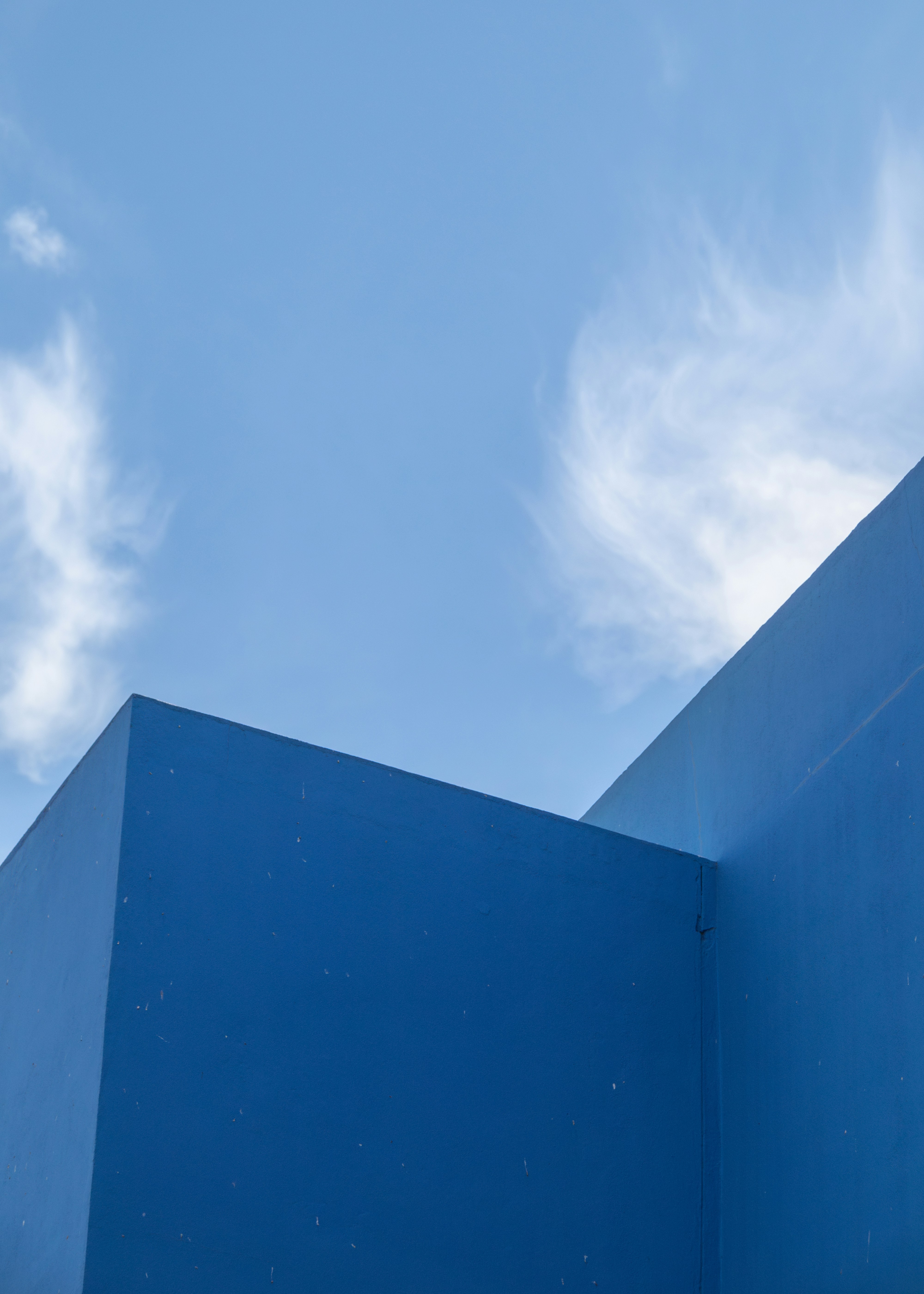 A blue building with a clock on the side of it