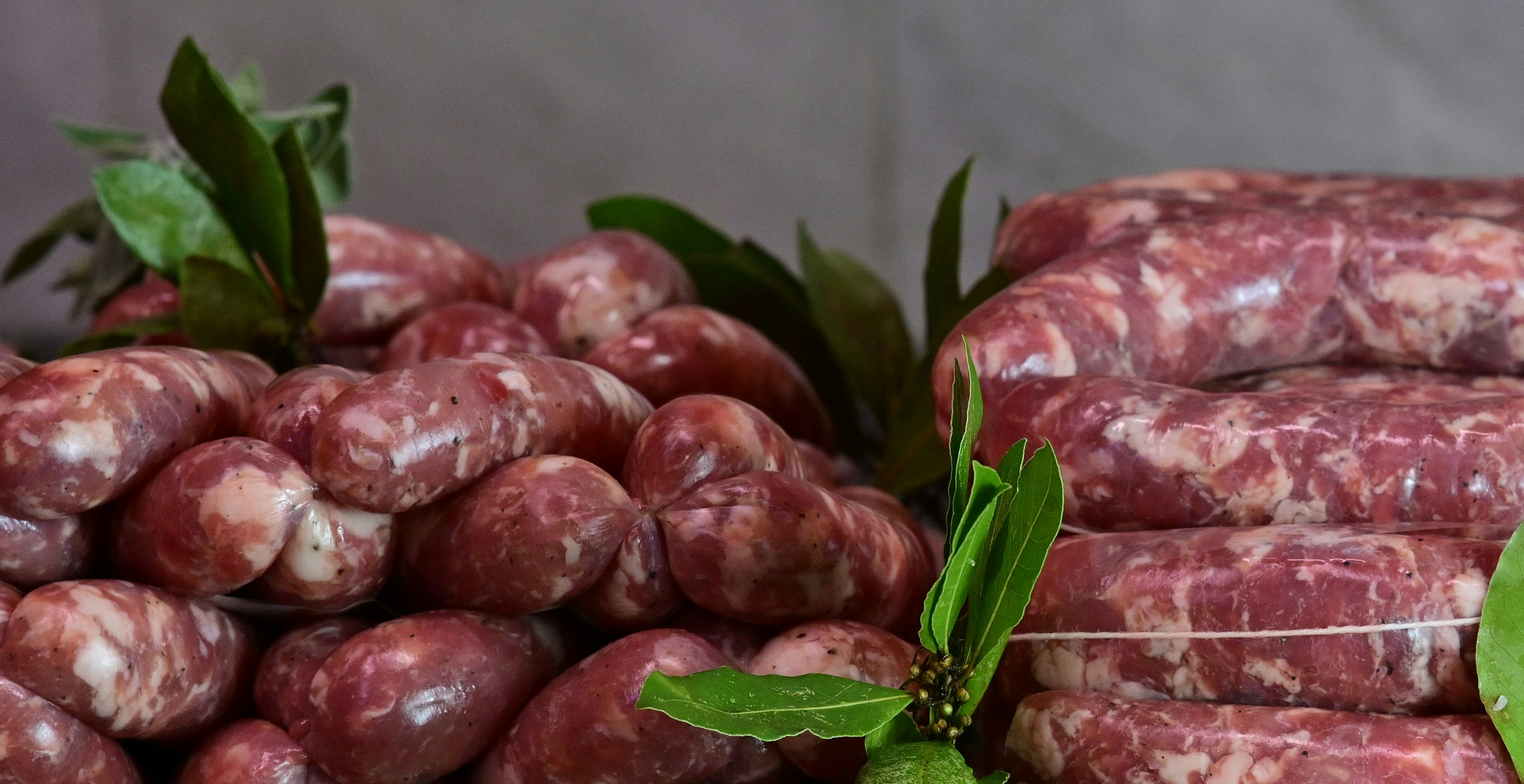 A pile of raw meat sitting next to a pile of green leaves